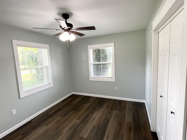 612 NE Powell Dr, Fort Walton Beach, FL 32547 - unfurnished bedroom featuring a closet, multiple windows, dark wood-style floors, and ceiling fan