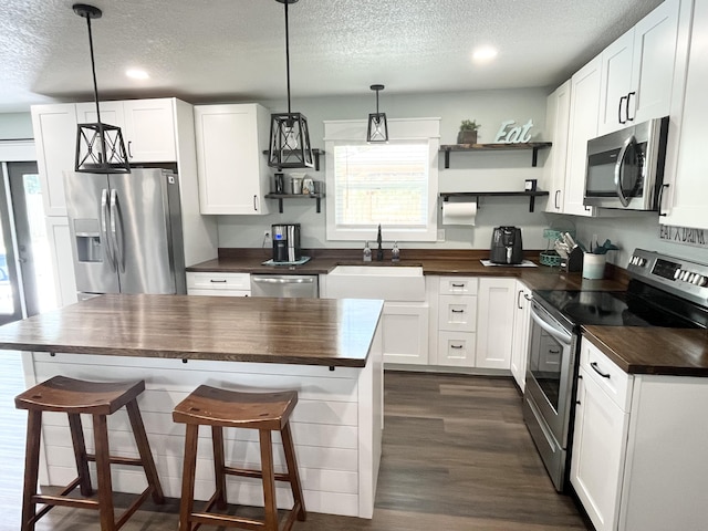 612 NE Powell Dr, Fort Walton Beach, FL 32547 - kitchen featuring stainless steel appliances, butcher block counters, a textured ceiling, open shelves, and recessed lighting