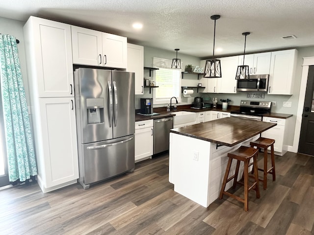 612 NE Powell Dr, Fort Walton Beach, FL 32547 - kitchen with appliances with stainless steel finishes, open shelves, dark wood-type flooring, white cabinets, and a textured ceiling