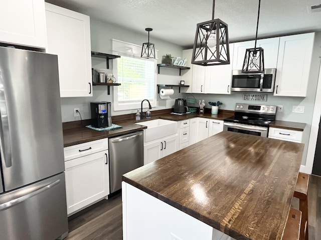 612 NE Powell Dr, Fort Walton Beach, FL 32547 - kitchen featuring appliances with stainless steel finishes, open shelves, wooden counters, dark wood finished floors, and white cabinetry