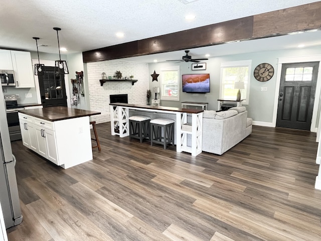 612 NE Powell Dr, Fort Walton Beach, FL 32547 - kitchen featuring open floor plan, dark countertops, ceiling fan, stainless steel appliances, and a textured ceiling