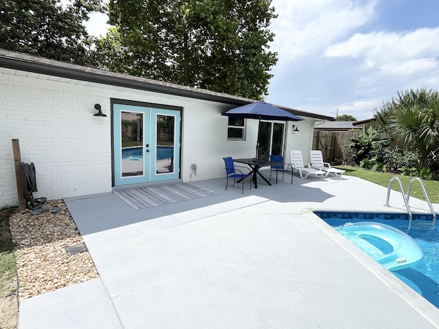 612 NE Powell Dr, Fort Walton Beach, FL 32547 - rear view of property with a hot tub, french doors, brick siding, and a patio area