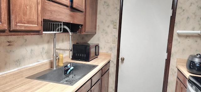 904 Tokalon Ct, Fort Walton Beach, FL 32547 - kitchen featuring black microwave, wallpapered walls, a wood stove, light countertops, and range