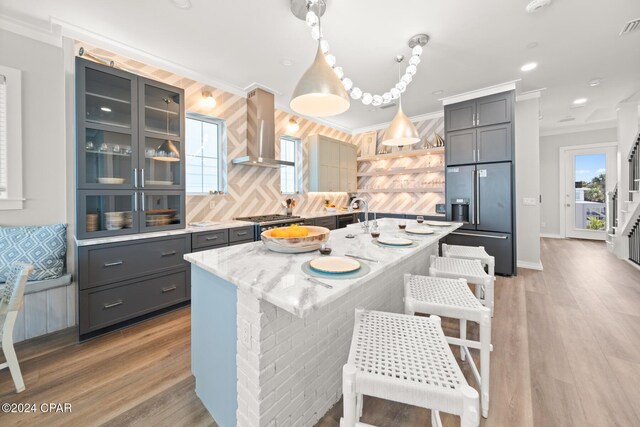 19989 Front Beach Rd, Panama City Beach, FL 32413 - kitchen with stainless steel built in refrigerator, wall chimney range hood, gray cabinets, light wood-style flooring, and crown molding