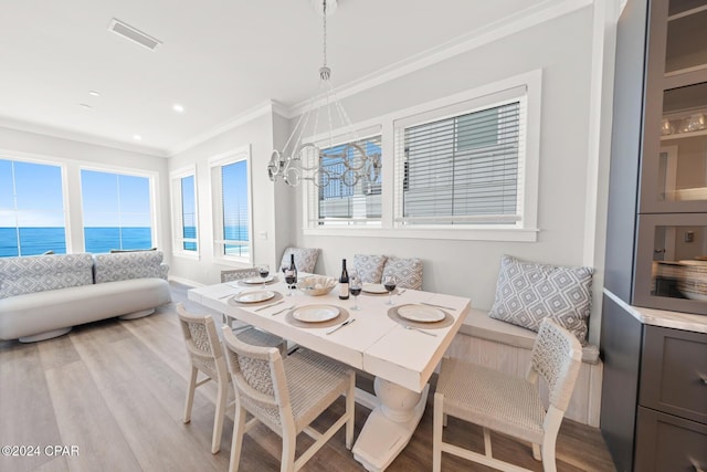 19989 Front Beach Rd, Panama City Beach, FL 32413 - dining space with crown molding, light wood-style floors, and a water view