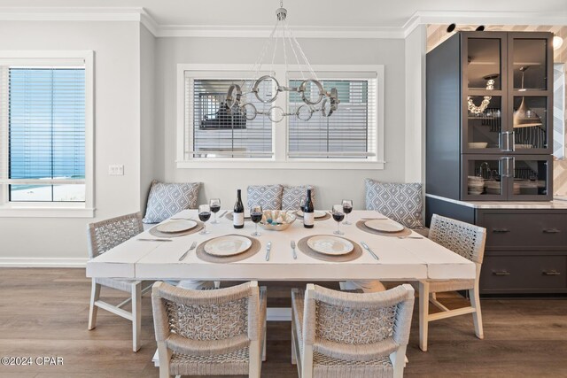 19989 Front Beach Rd, Panama City Beach, FL 32413 - dining room featuring ornamental molding, a chandelier, wood finished floors, and plenty of natural light