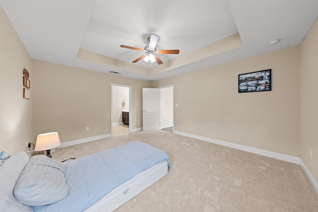 8152 Nevada St, Navarre, FL 32566 - bedroom featuring a tray ceiling, light colored carpet, ceiling fan, and ensuite bath