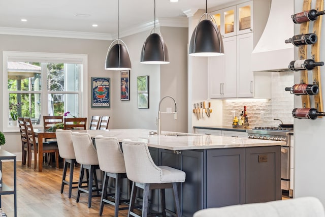 508 W Point Washington Rd, Santa Rosa Beach, FL 32459 - kitchen with high end stove, premium range hood, light wood-type flooring, backsplash, and light stone countertops