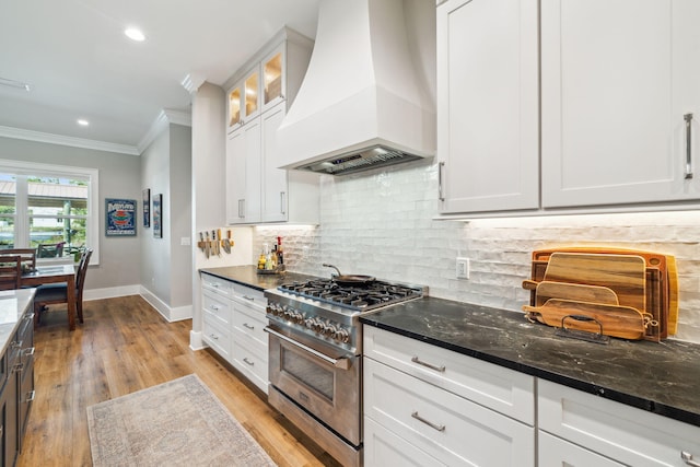 508 W Point Washington Rd, Santa Rosa Beach, FL 32459 - kitchen featuring custom exhaust hood, stainless steel range, ornamental molding, dark stone countertops, and light wood finished floors