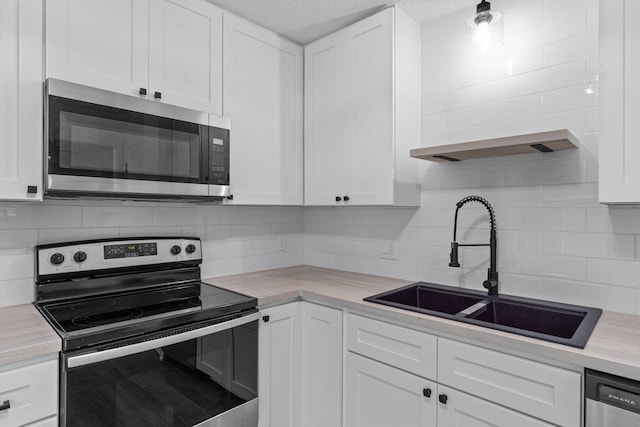 1816 Madelons Path, Fort Walton Beach, FL 32547 - kitchen with stainless steel appliances, white cabinets, light countertops, and decorative backsplash