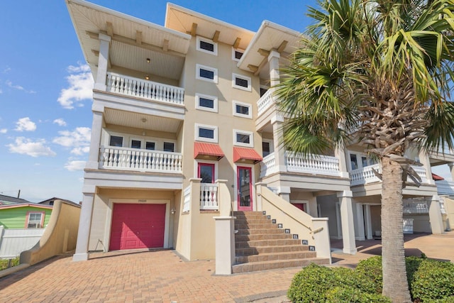 19108 Front Beach Rd Unit A & B, Panama City Beach, FL 32413 - view of front of home featuring a garage, stucco siding, decorative driveway, and a balcony