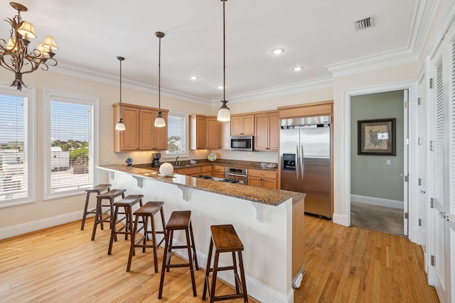 19108 Front Beach Rd Unit A & B, Panama City Beach, FL 32413 - kitchen featuring stainless steel appliances, a peninsula, a kitchen breakfast bar, light wood-type flooring, and crown molding