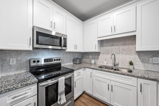 1819 Stable Ln, Fort Walton Beach, FL 32547 - kitchen with appliances with stainless steel finishes, decorative backsplash, white cabinets, and light stone counters
