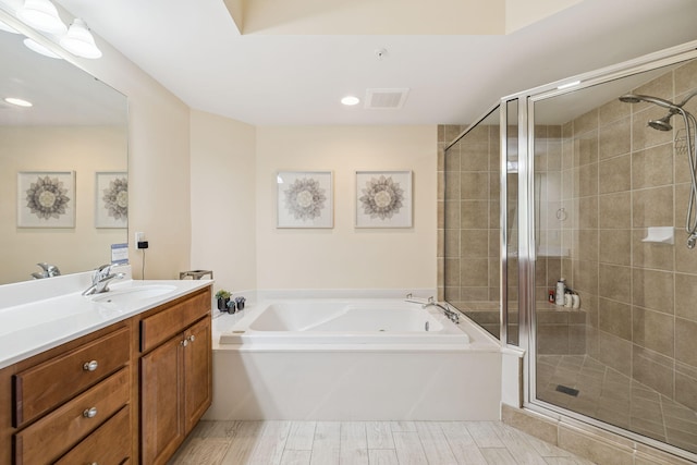 15100 Emerald Coast Pkwy Unit 602, Destin, FL 32541 - full bath featuring vanity, a bath, a shower stall, wood finished floors, and recessed lighting