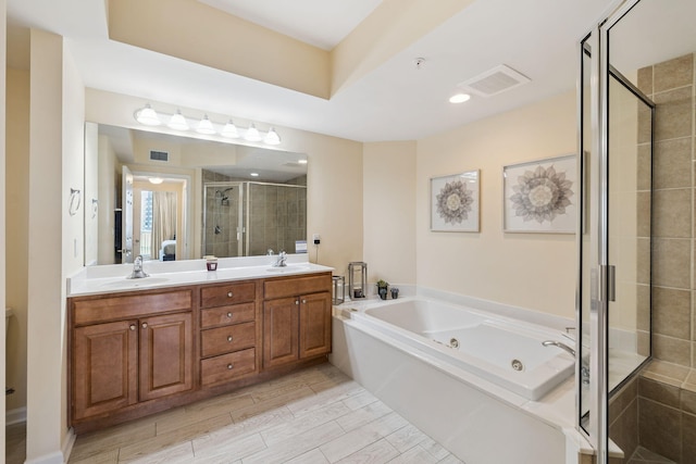 15100 Emerald Coast Pkwy Unit 602, Destin, FL 32541 - full bathroom featuring a stall shower, a whirlpool tub, double vanity, and wood tiled floors