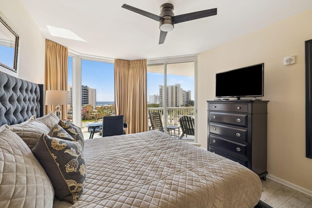 15100 Emerald Coast Pkwy Unit 602, Destin, FL 32541 - bedroom with access to exterior, multiple windows, expansive windows, wood finished floors, and a ceiling fan