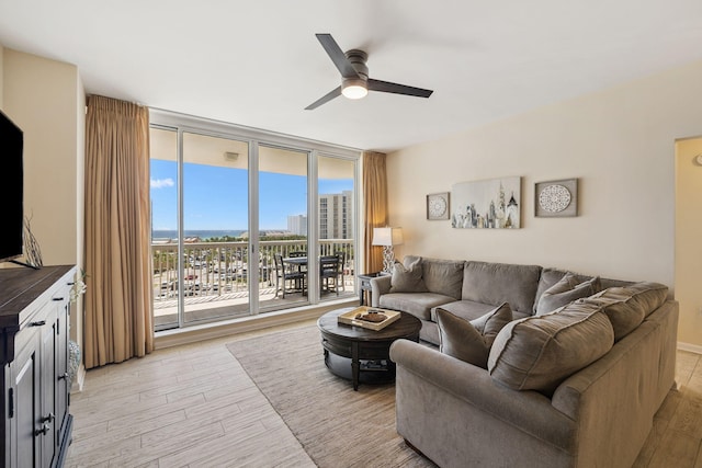 15100 Emerald Coast Pkwy Unit 602, Destin, FL 32541 - living room with expansive windows, ceiling fan, and light wood-type flooring