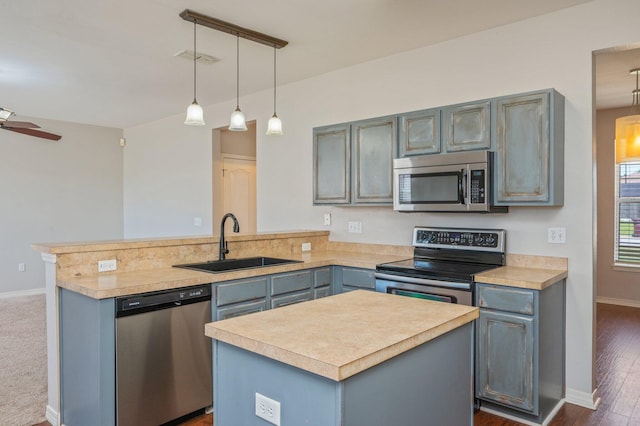 715 Presscott St, Crestview, FL 32536 - kitchen with stainless steel appliances, a peninsula, light countertops, decorative light fixtures, and gray cabinetry