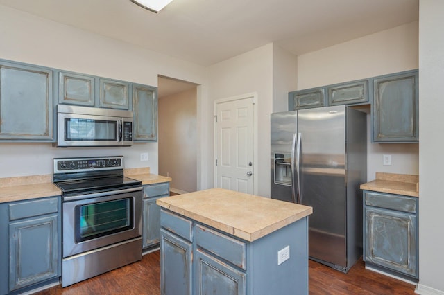 715 Presscott St, Crestview, FL 32536 - kitchen featuring appliances with stainless steel finishes, light countertops, dark wood-style floors, and blue cabinetry