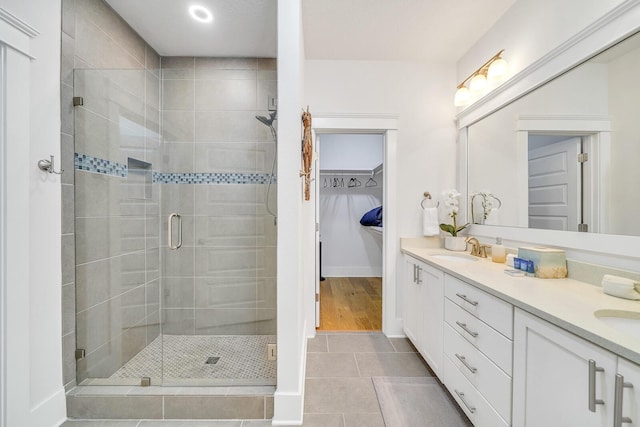 386 Grande Pointe Cir, Inlet Beach, FL 32461 - bathroom featuring a stall shower, double vanity, tile patterned floors, and a spacious closet