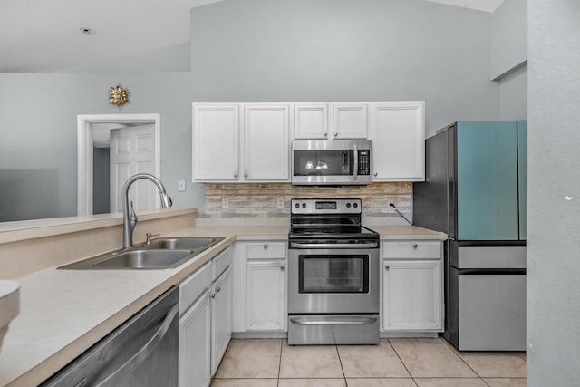 118 Cabana Way, Crestview, FL 32536 - kitchen with appliances with stainless steel finishes, light tile patterned floors, white cabinetry, tasteful backsplash, and vaulted ceiling