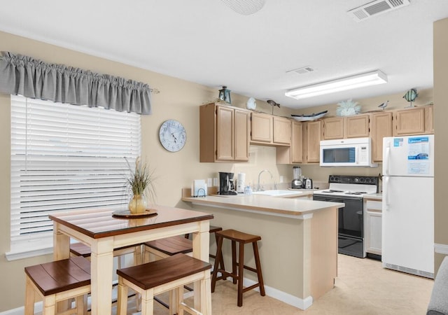 2396 Scenic Gulf Dr Unit 210, Miramar Beach, FL 32550 - kitchen with white appliances, light brown cabinetry, a peninsula, and light countertops