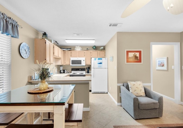 2396 Scenic Gulf Dr Unit 210, Miramar Beach, FL 32550 - kitchen featuring white appliances, light brown cabinetry, light countertops, a peninsula, and light tile patterned floors