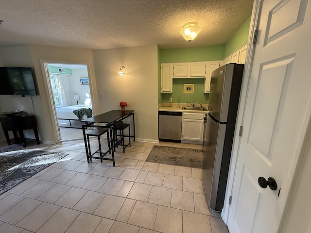 200 Sandestin Ln Unit 612, Miramar Beach, FL 32550 - kitchen featuring stainless steel appliances, a textured ceiling, white cabinetry, light countertops, and light tile patterned floors