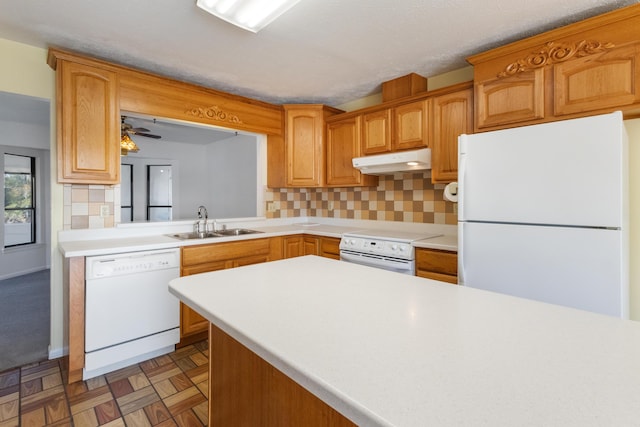 702 Beachcomber Dr, Lynn Haven, FL 32444 - kitchen with white appliances, under cabinet range hood, light countertops, and tasteful backsplash