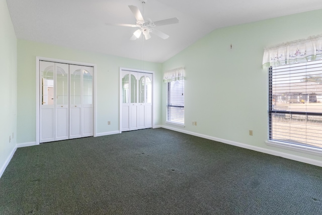 702 Beachcomber Dr, Lynn Haven, FL 32444 - unfurnished bedroom featuring two closets, dark carpet, lofted ceiling, and ceiling fan