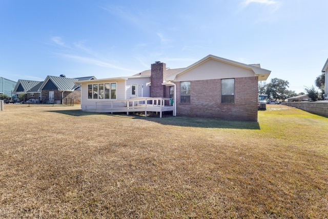 702 Beachcomber Dr, Lynn Haven, FL 32444 - rear view of property with brick siding, a deck, and a chimney