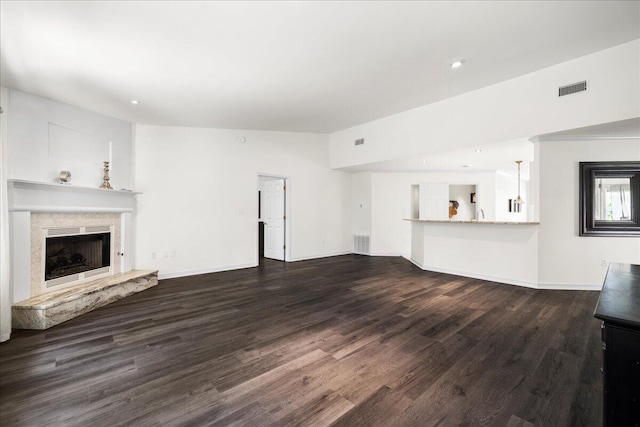 3928 Mesa Rd, Destin, FL 32541 - unfurnished living room with a high end fireplace, dark wood-style floors, and recessed lighting