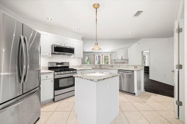 3928 Mesa Rd, Destin, FL 32541 - kitchen with appliances with stainless steel finishes, a peninsula, light tile patterned floors, a center island, and white cabinets