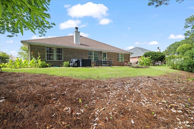 3928 Mesa Rd, Destin, FL 32541 - back of house with a chimney, brick siding, and a yard