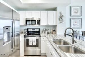 17757 Front Beach Rd Unit 507, Panama City Beach, FL 32413 - kitchen featuring stainless steel appliances, white cabinetry, and light stone countertops