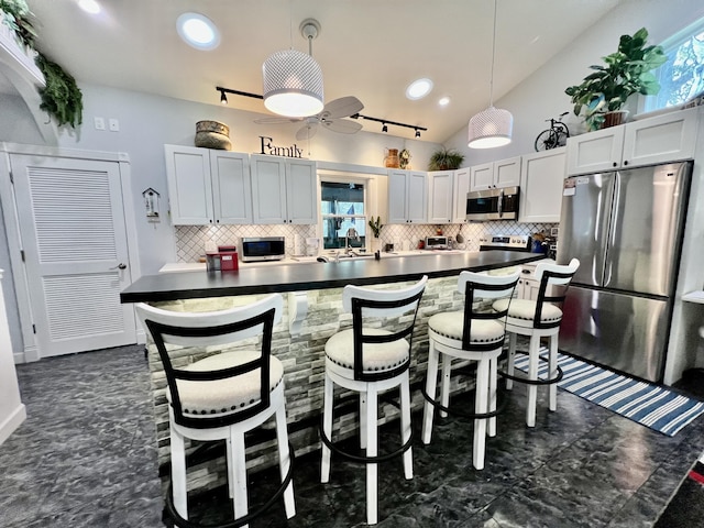 226 N Marsh Lndg, Freeport, FL 32439 - kitchen with stainless steel appliances, dark countertops, tasteful backsplash, vaulted ceiling, and a ceiling fan