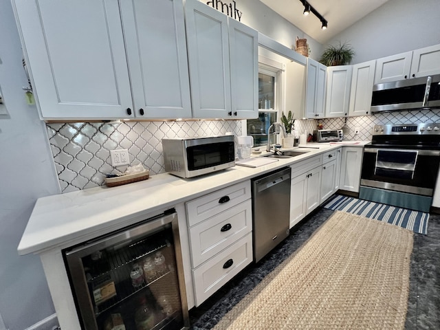 226 N Marsh Lndg, Freeport, FL 32439 - kitchen with appliances with stainless steel finishes, wine cooler, backsplash, light countertops, and vaulted ceiling