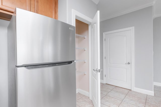 289 Mattie M Kelly Blvd, Destin, FL 32541 - kitchen with freestanding refrigerator, light tile patterned flooring, and ornamental molding