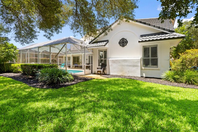 96 Garnet Pl, Destin, FL 32541 - back of property with a tiled roof, an outdoor pool, a lawn, and stucco siding