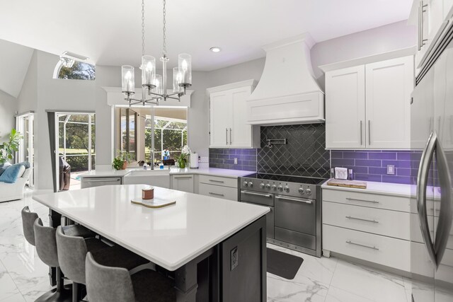 96 Garnet Pl, Destin, FL 32541 - kitchen featuring appliances with stainless steel finishes, premium range hood, light marble finish floors, white cabinetry, and light countertops