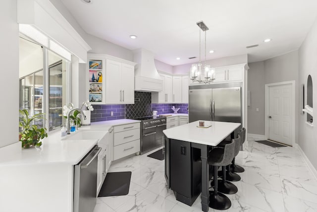 96 Garnet Pl, Destin, FL 32541 - kitchen with premium appliances, custom exhaust hood, white cabinets, recessed lighting, and backsplash