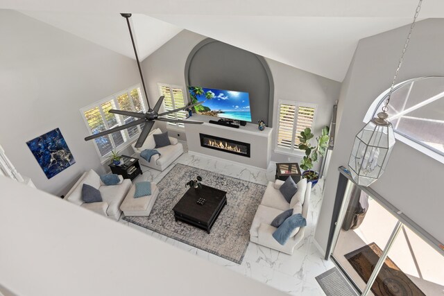 96 Garnet Pl, Destin, FL 32541 - living room featuring marble look tile flooring, high vaulted ceiling, a glass covered fireplace, healthy amount of natural light, and ceiling fan