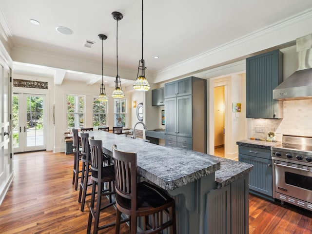 16 Beachberry Ln, Santa Rosa Beach, FL 32459 - kitchen with designer stove, wall chimney exhaust hood, dark wood-type flooring, decorative backsplash, and a breakfast bar