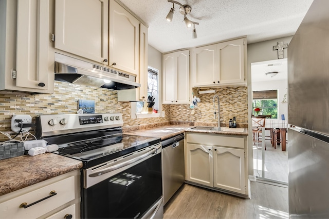 965 B St, Crestview, FL 32536 - kitchen with stainless steel appliances, under cabinet range hood, light wood-style flooring, a textured ceiling, and tasteful backsplash