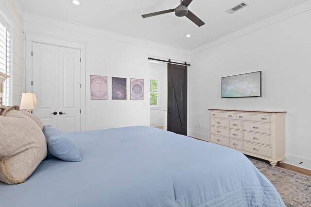 257 Matts Way, Santa Rosa Beach, FL 32459 - bedroom with a barn door, crown molding, recessed lighting, a closet, and wood finished floors