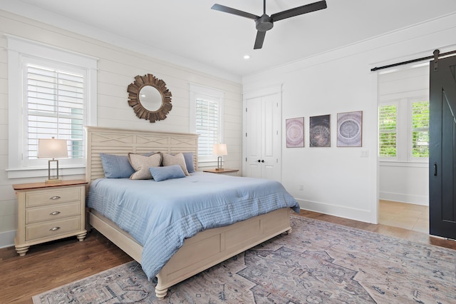 257 Matts Way, Santa Rosa Beach, FL 32459 - bedroom with a barn door, wood finished floors, a ceiling fan, a closet, and crown molding