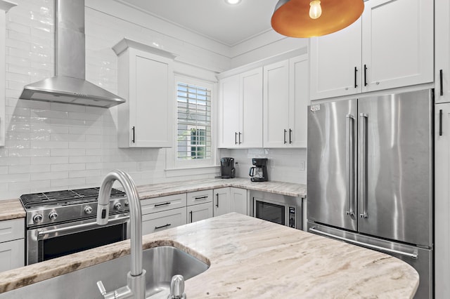 257 Matts Way, Santa Rosa Beach, FL 32459 - kitchen with stainless steel appliances, wall chimney exhaust hood, tasteful backsplash, and white cabinetry