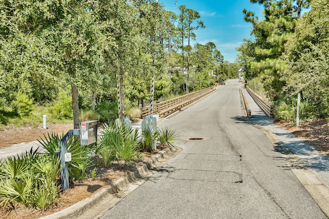 257 Matts Way, Santa Rosa Beach, FL 32459 - view of asphalt road featuring curbs and view of wooded area
