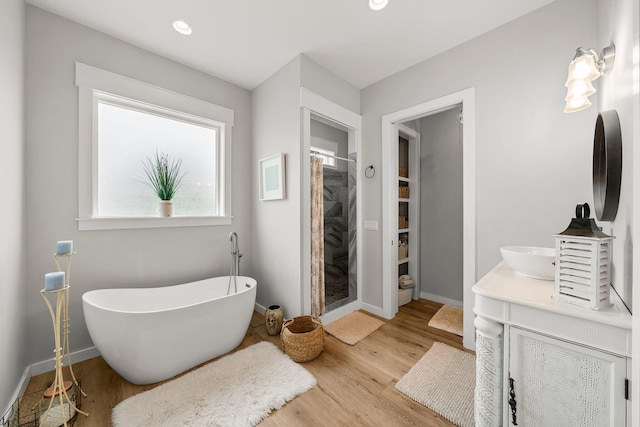 71 Childers Ln, Freeport, FL 32439 - full bathroom with wood finished floors, a stall shower, a freestanding tub, vanity, and recessed lighting
