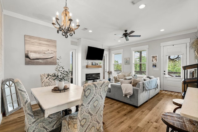 71 Childers Ln, Freeport, FL 32439 - dining space with ornamental molding, light wood-style flooring, a glass covered fireplace, recessed lighting, and a chandelier